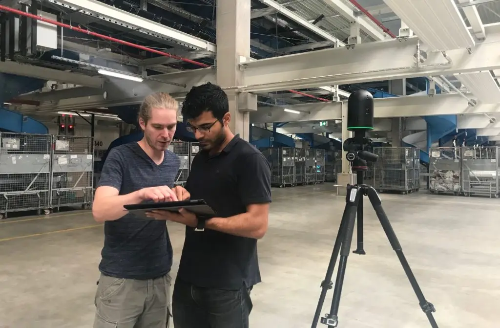 Zwei Personen mit Tablet und 3D-Kamera im Hermes LogistikCenter