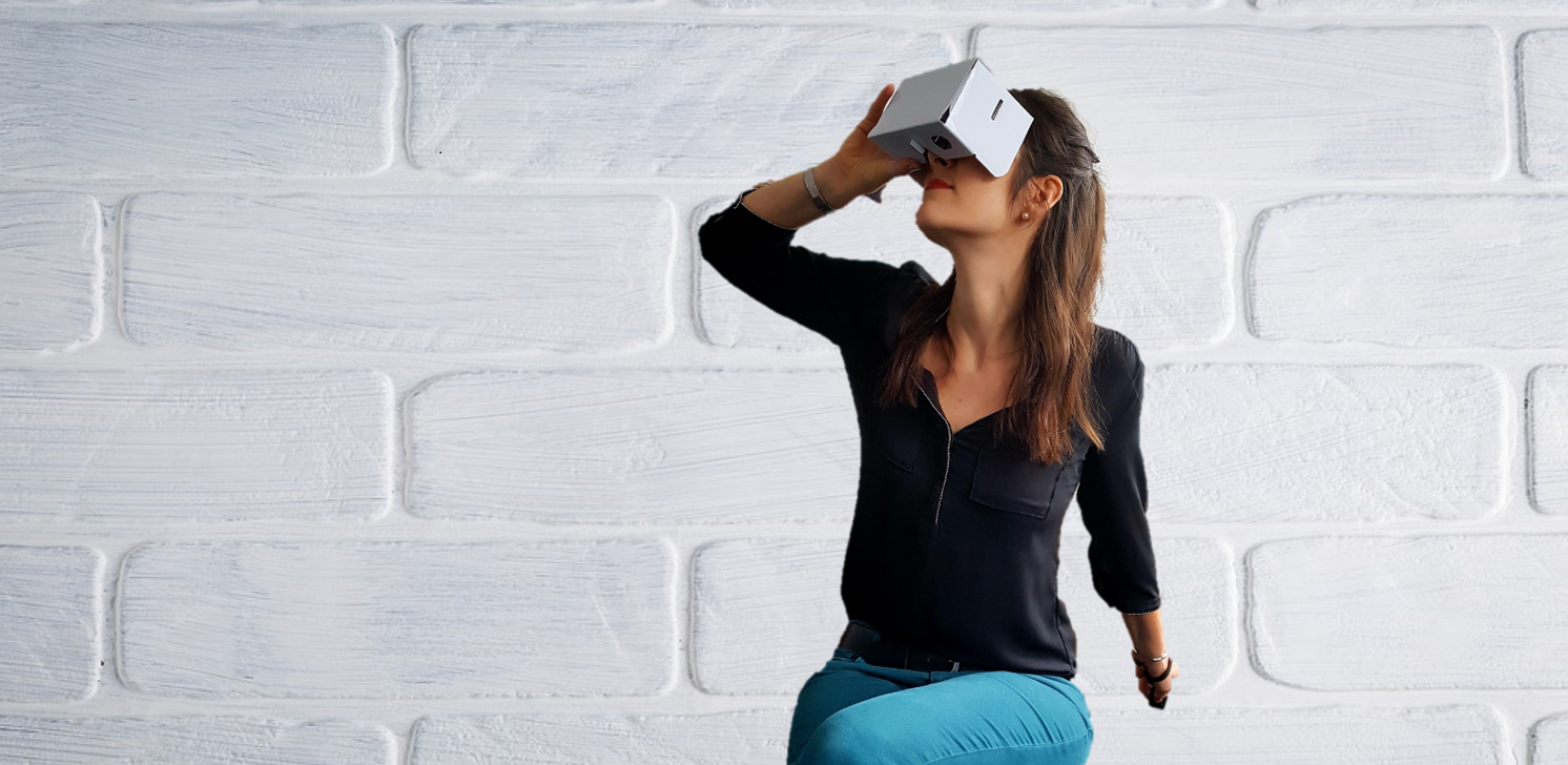 Frau mit VR-Brille vor einer weißen Wand