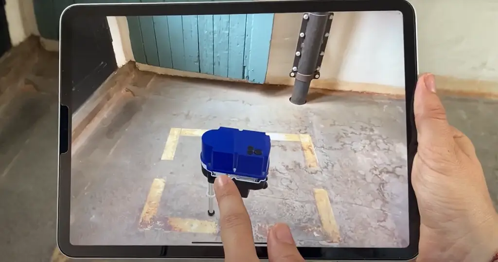 Tablet zeigt ein 3D-Produkt per Augmented Reality auf dem Hallenboden