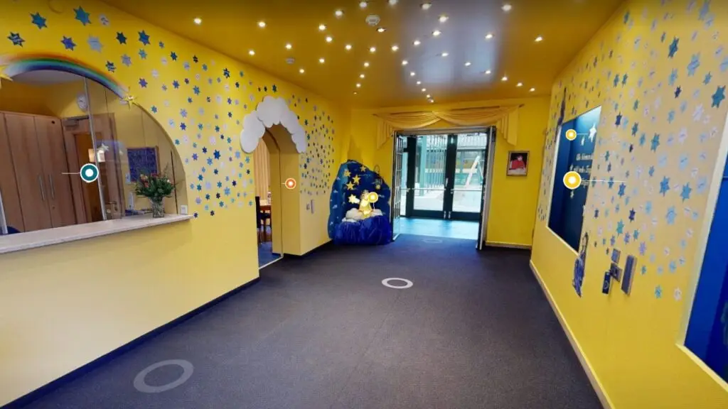 Eingangsbereich des Kinderhospizes Sternenbrücke mit Sternen an gelben Wänden im virtuellen Rundgang