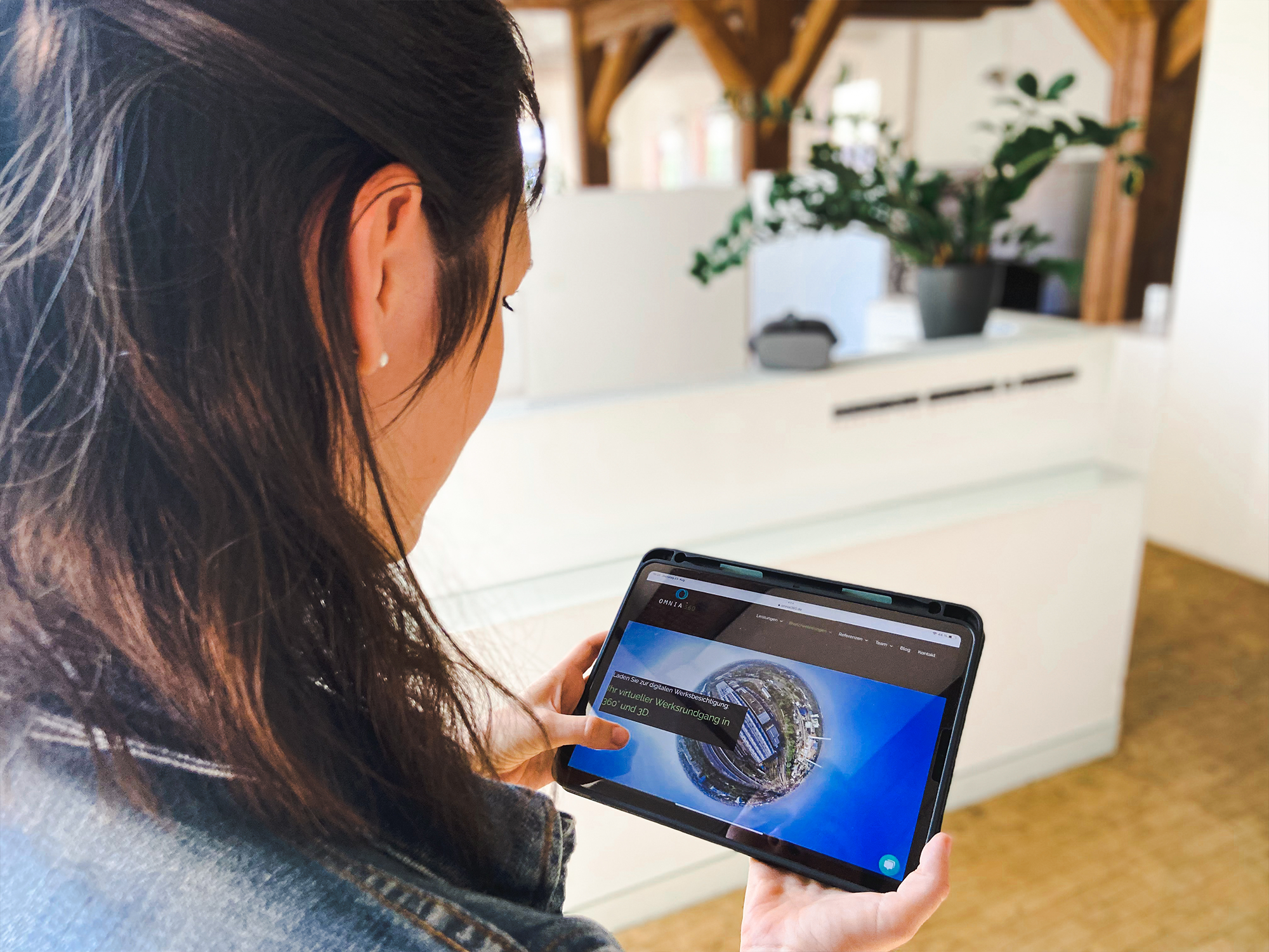 omnia360 Gründerin Claudia checkt auf dem Tablet die Branchenlösungen der VR Agentur